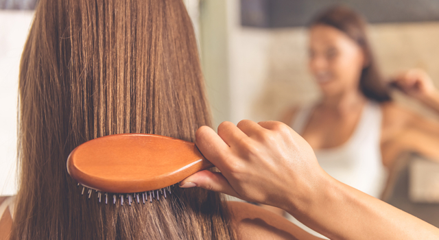 femme se coiffant les cheveux
